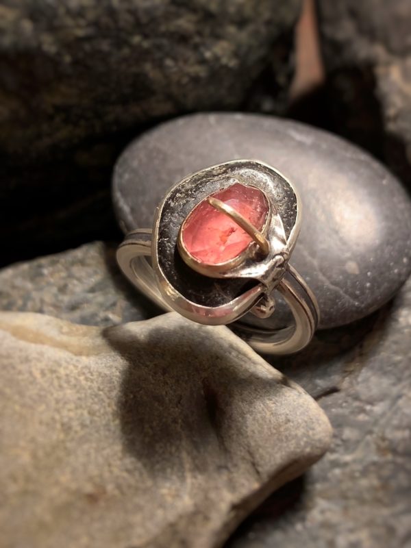 Ausgefallener Ring mit einem schwarzen Kiesel, der einen rosafarbenen Turmalin obenauf trägt