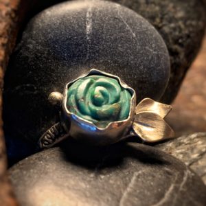 Floral gestalteter Ring mit einem Türkis, der zu einer kleinen Rose geschnitzt (gecarvt) wurde; Ausführung in Gelbgold und Sterlingsilber