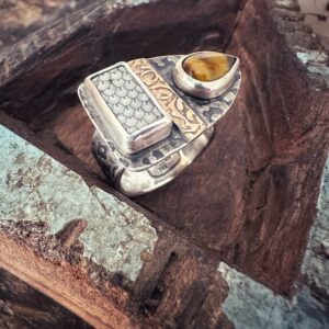 Außergewöhnlicher Ring mit einer Snakeskin-Versteinerung, einem Tigerauge und vielen Mustern. Dass mittlere Band obenauf ist aus Gelbgold.