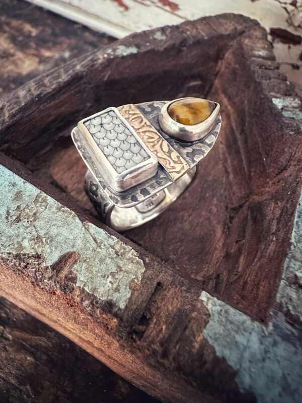 Außergewöhnlicher Ring mit einer Snakeskin-Versteinerung, einem Tigerauge und vielen Mustern. Dass mittlere Band obenauf ist aus Gelbgold.