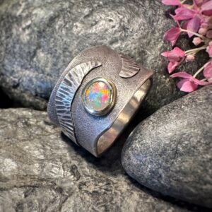 Handgearbeiteter Unisex-Ring mit gehämmerten Strukturen und einem farbintensiven Lightning Ridge Opal in Gelbgoldfassung.