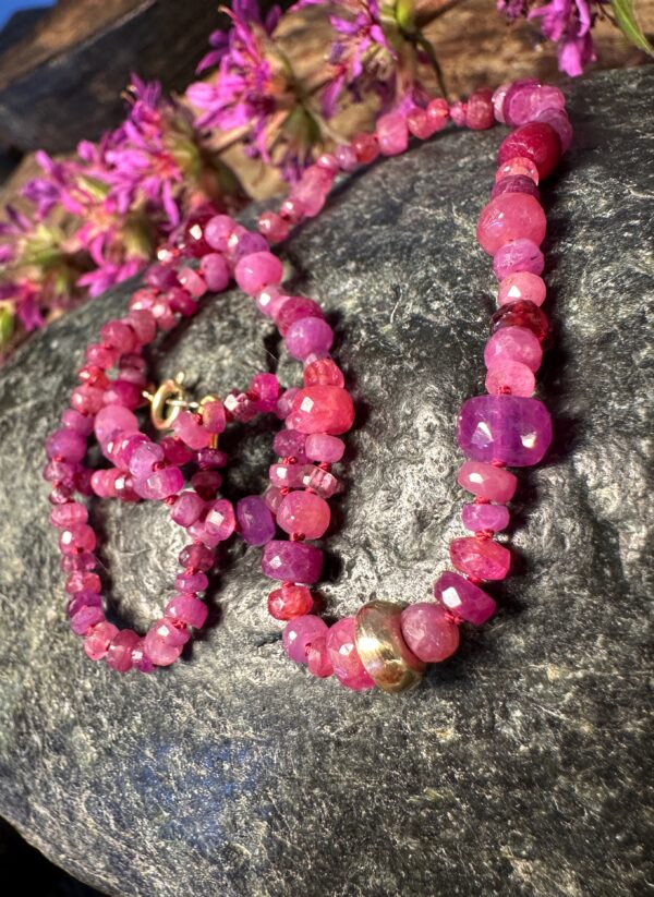 Handgeknüpfte Kette mit farblich schön variierenden, pinken Rubinen und Goldperle.
