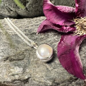 Detailreicher und doch schlichter Anhänger mit einer Süßwasserperle, in Handarbeit gefasst in Sterlingsilber mit Gelbgoldkugel